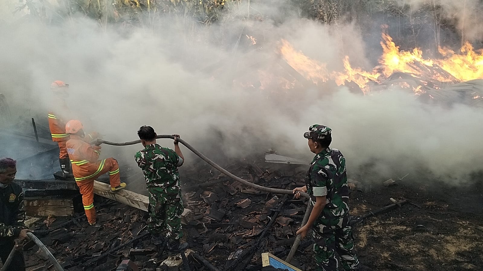 Babinsa Padas  dan Warga Bahu Membahu Padamkan Kebakaran Lahan Perusahaan Kayu